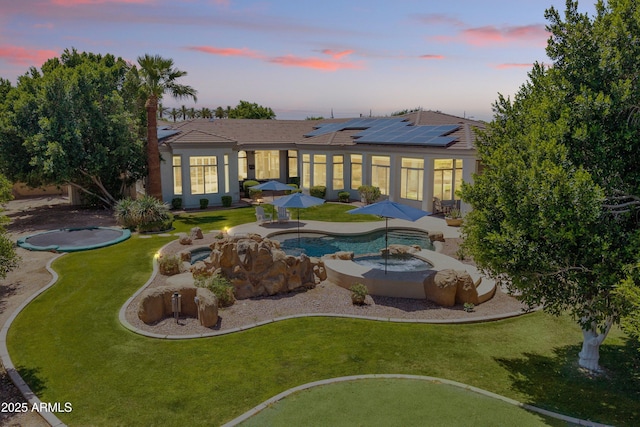 3410 E Inglewood Cir, Mesa, AZ 85213 - back of property at dusk with stucco siding, an outdoor pool, a patio area, a tiled roof, and a yard