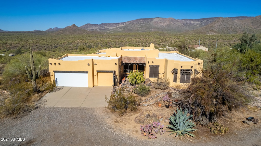 pueblo-style house featuring a mountain view and a garage