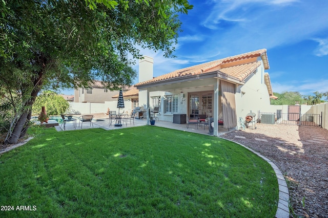 back of property with a lawn, a patio area, and central air condition unit