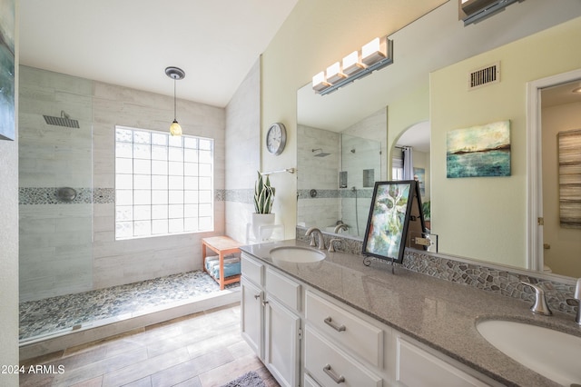 bathroom featuring tile patterned flooring, vanity, and tiled shower