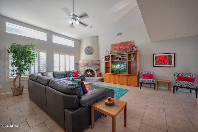 living room with ceiling fan, a fireplace, light tile patterned floors, and high vaulted ceiling