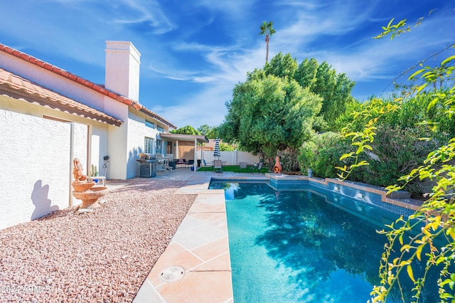 view of swimming pool featuring area for grilling and a patio