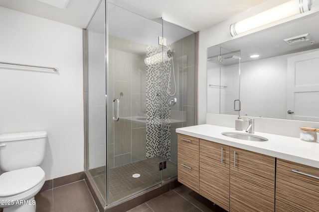 bathroom with tile patterned floors, vanity, toilet, and a shower with shower door