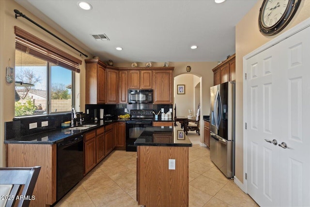 kitchen with sink, black appliances, light tile patterned floors, a kitchen island, and backsplash