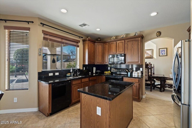 kitchen with sink, black appliances, a center island, dark stone counters, and backsplash