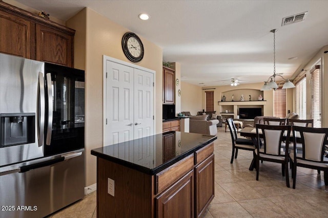 kitchen with a kitchen island, hanging light fixtures, light tile patterned floors, ceiling fan, and stainless steel fridge with ice dispenser