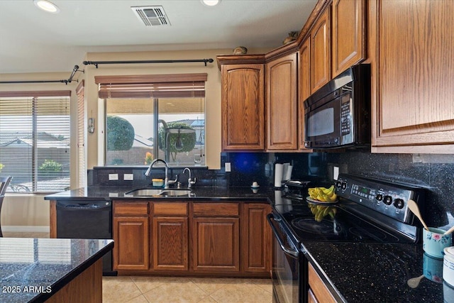 kitchen featuring tasteful backsplash, sink, dark stone countertops, light tile patterned floors, and black appliances