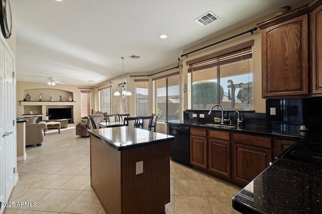 kitchen featuring a center island, black dishwasher, sink, and light tile patterned floors