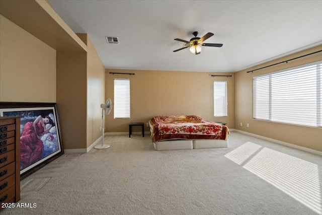 carpeted bedroom with multiple windows and ceiling fan