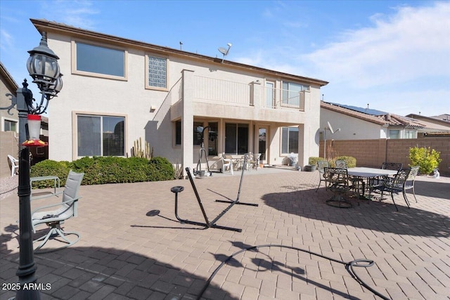 rear view of property featuring a balcony and a patio area