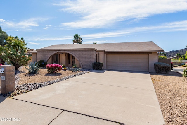 view of front facade with a garage, brick siding, and driveway