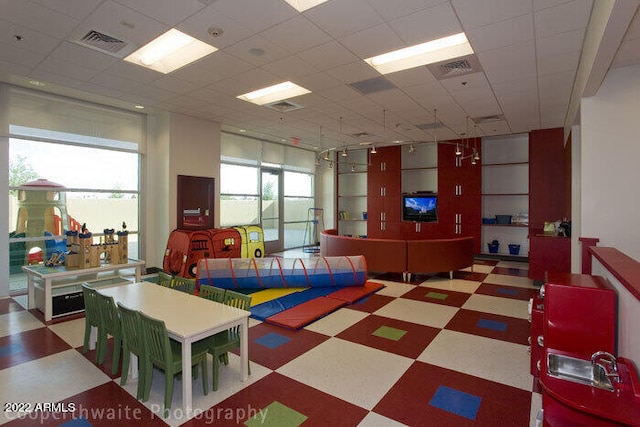rec room featuring visible vents, a drop ceiling, and tile patterned floors