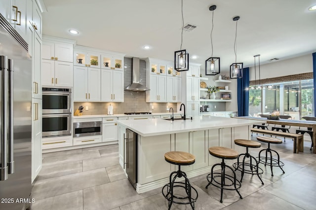 1890 E Sagittarius Pl, Chandler, AZ 85249 - kitchen with stainless steel appliances, wall chimney range hood, a sink, light countertops, and decorative backsplash
