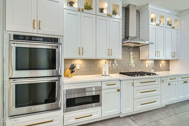 1890 E Sagittarius Pl, Chandler, AZ 85249 - kitchen with stainless steel appliances, wall chimney exhaust hood, light countertops, decorative backsplash, and white cabinets