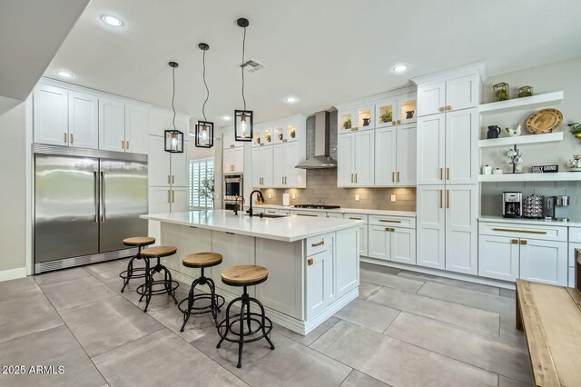 1890 E Sagittarius Pl, Chandler, AZ 85249 - kitchen featuring stainless steel appliances, wall chimney range hood, light countertops, white cabinets, and a breakfast bar area