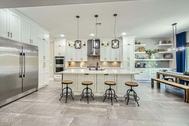1890 E Sagittarius Pl, Chandler, AZ 85249 - kitchen with appliances with stainless steel finishes, wall chimney exhaust hood, light countertops, backsplash, and recessed lighting