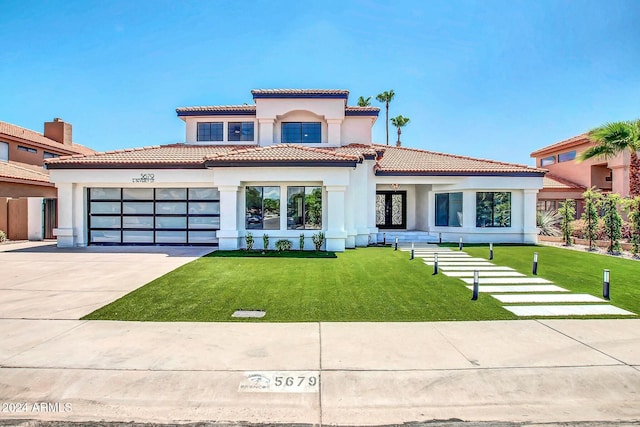 mediterranean / spanish house with a front lawn and a garage