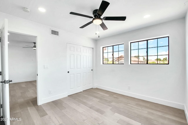 unfurnished bedroom with ceiling fan, a closet, and light hardwood / wood-style floors