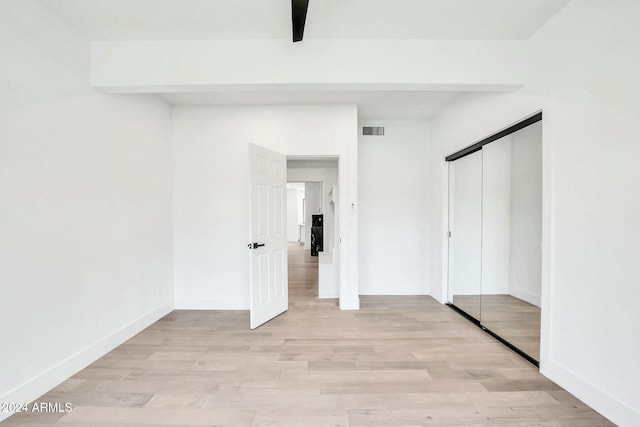 unfurnished bedroom featuring a closet and light wood-type flooring