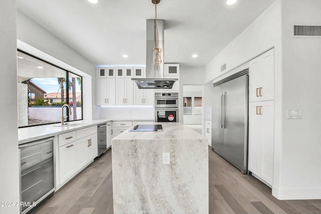 kitchen with white cabinetry, sink, a center island, hanging light fixtures, and appliances with stainless steel finishes