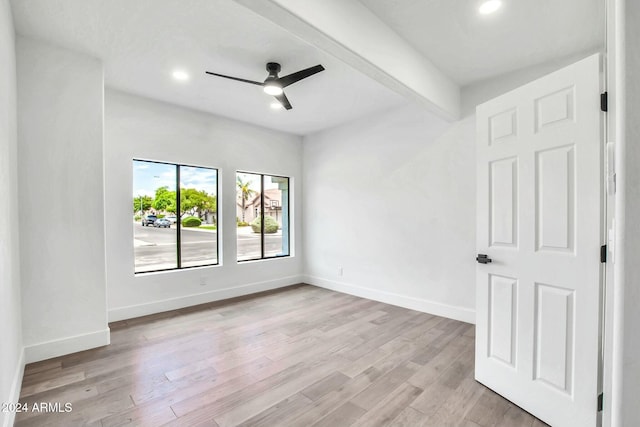 spare room featuring beam ceiling, ceiling fan, and light hardwood / wood-style floors