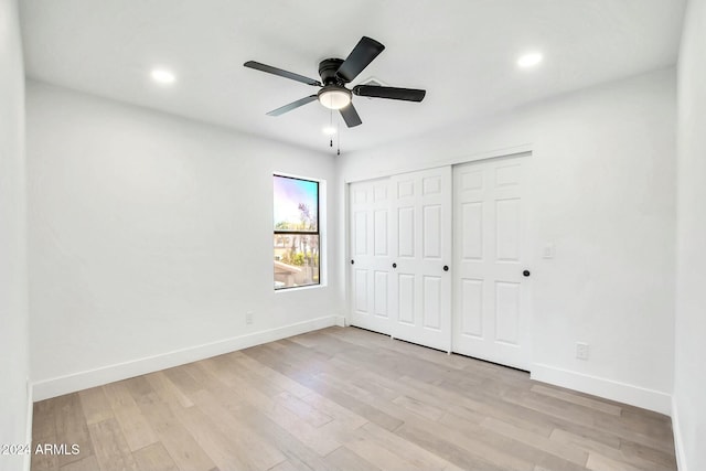 unfurnished bedroom with ceiling fan, a closet, and light hardwood / wood-style flooring