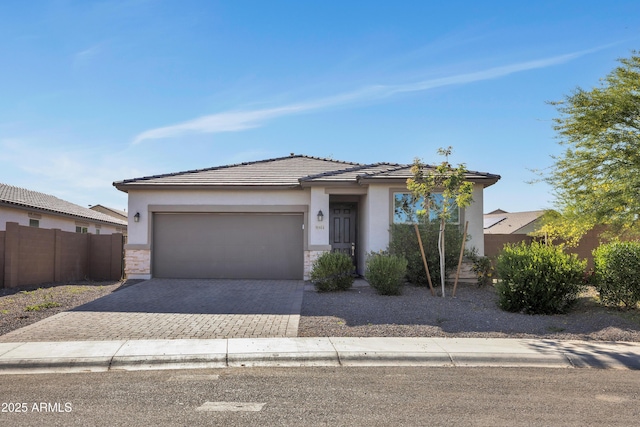 8944 N 180th Dr, Waddell, AZ 85355 - view of front of house featuring a tiled roof, stucco siding, decorative driveway, fence, and a garage