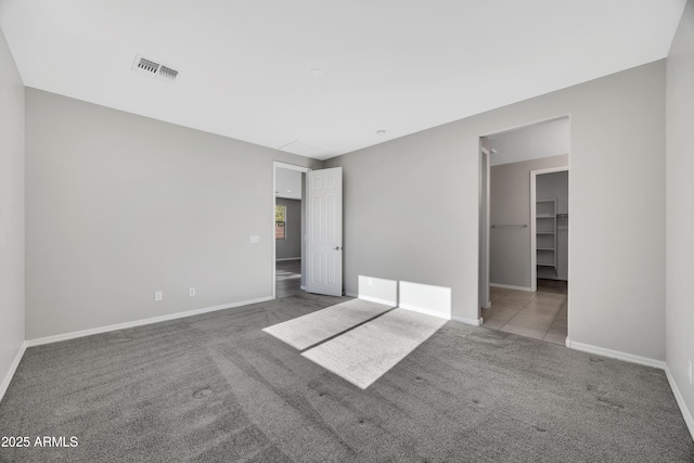8944 N 180th Dr, Waddell, AZ 85355 - unfurnished bedroom with a walk in closet, baseboards, visible vents, and carpet floors