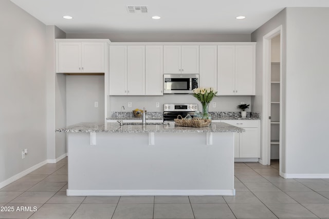 8944 N 180th Dr, Waddell, AZ 85355 - kitchen featuring visible vents, white cabinets, a center island with sink, and stainless steel appliances
