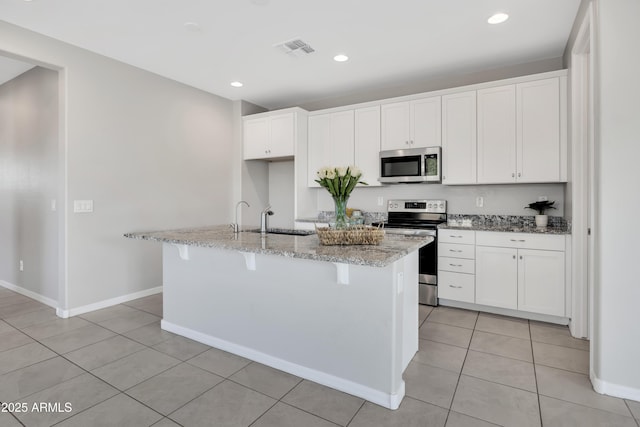 8944 N 180th Dr, Waddell, AZ 85355 - kitchen with white cabinets, visible vents, a center island with sink, appliances with stainless steel finishes, and a sink