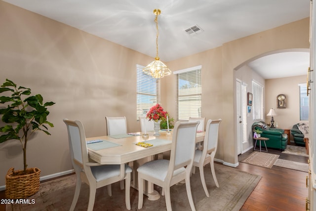 dining area with dark hardwood / wood-style flooring and a chandelier