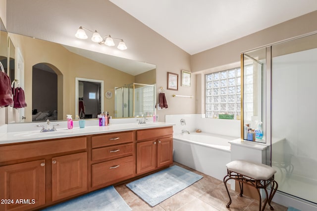 bathroom with tile patterned flooring, vanity, lofted ceiling, and shower with separate bathtub