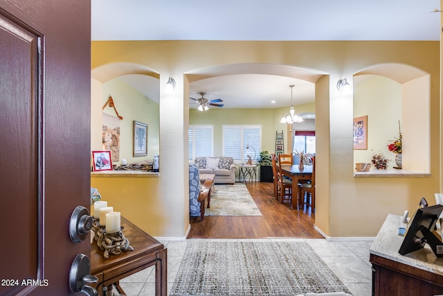 interior space featuring ceiling fan with notable chandelier and light hardwood / wood-style floors