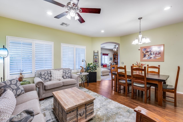 living room featuring hardwood / wood-style flooring and ceiling fan with notable chandelier