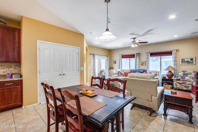 tiled dining space featuring ceiling fan