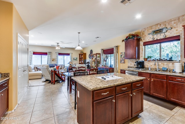 kitchen featuring pendant lighting, a wealth of natural light, sink, and a kitchen island