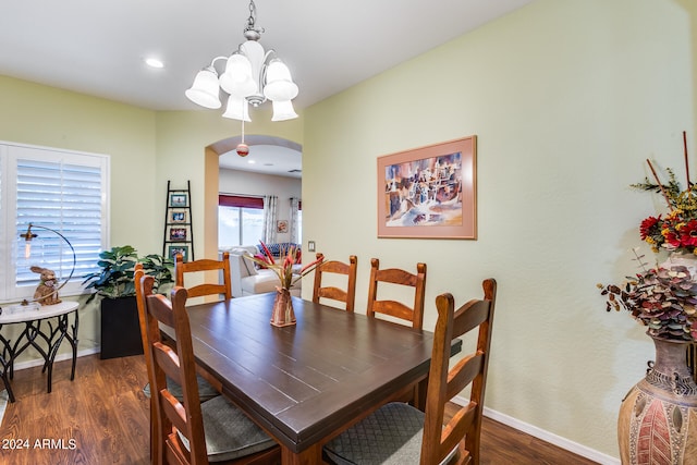 dining room with dark hardwood / wood-style floors and an inviting chandelier