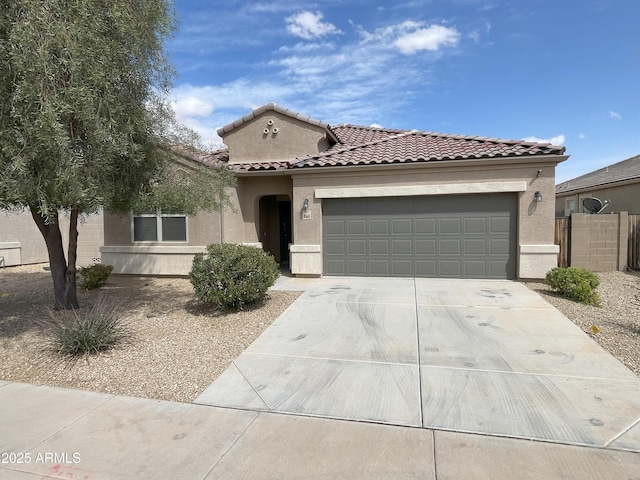mediterranean / spanish-style home featuring driveway, fence, a garage, a tile roof, and stucco siding