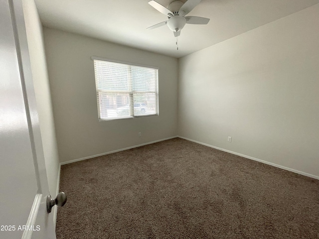 carpeted spare room featuring baseboards and ceiling fan
