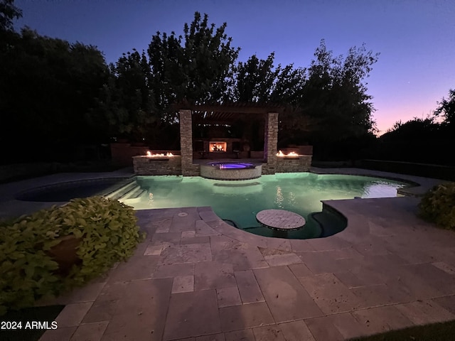 pool at dusk with an in ground hot tub and a patio