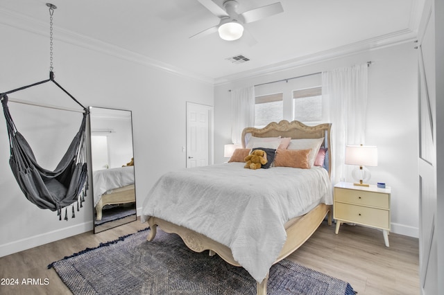 bedroom featuring ceiling fan, crown molding, and light hardwood / wood-style flooring