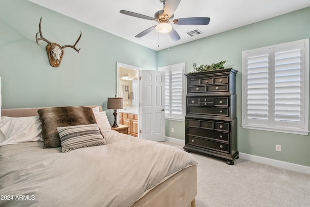 bedroom featuring ensuite bathroom, ceiling fan, and light colored carpet