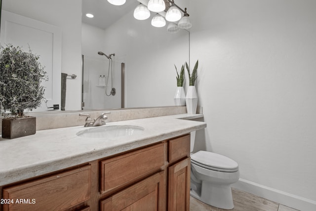 bathroom featuring toilet, vanity, and walk in shower