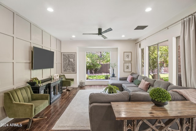 living room with ceiling fan, plenty of natural light, and dark hardwood / wood-style floors