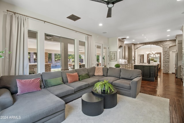 living room featuring wood-type flooring and ceiling fan with notable chandelier