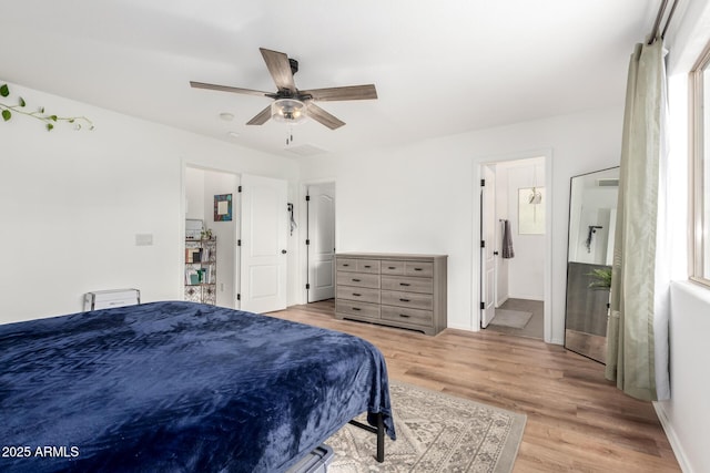 bedroom with ceiling fan, connected bathroom, and light wood-type flooring