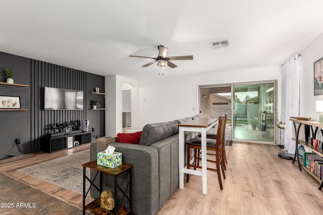 living room with ceiling fan and light hardwood / wood-style flooring