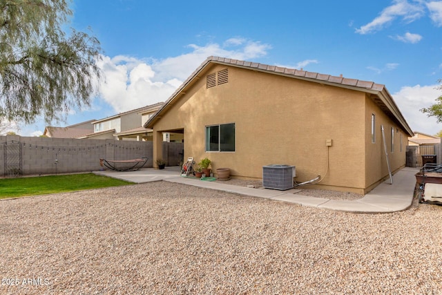 rear view of property featuring a patio and central air condition unit