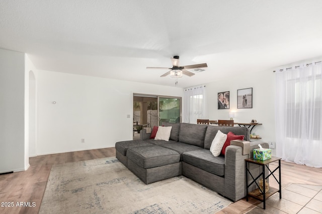 living room featuring a healthy amount of sunlight, ceiling fan, and light wood-type flooring