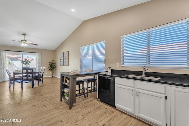 kitchen featuring white cabinetry, dishwasher, lofted ceiling, sink, and light hardwood / wood-style flooring